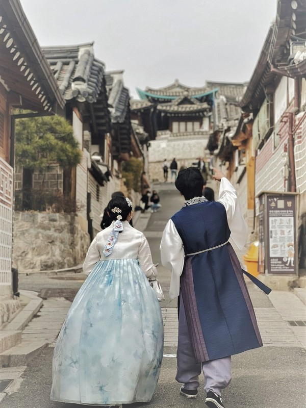 Người phụ nữ mặc Hanbok đứng trước cổng